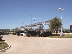 Line of cars in parking lot under commercial shade structure