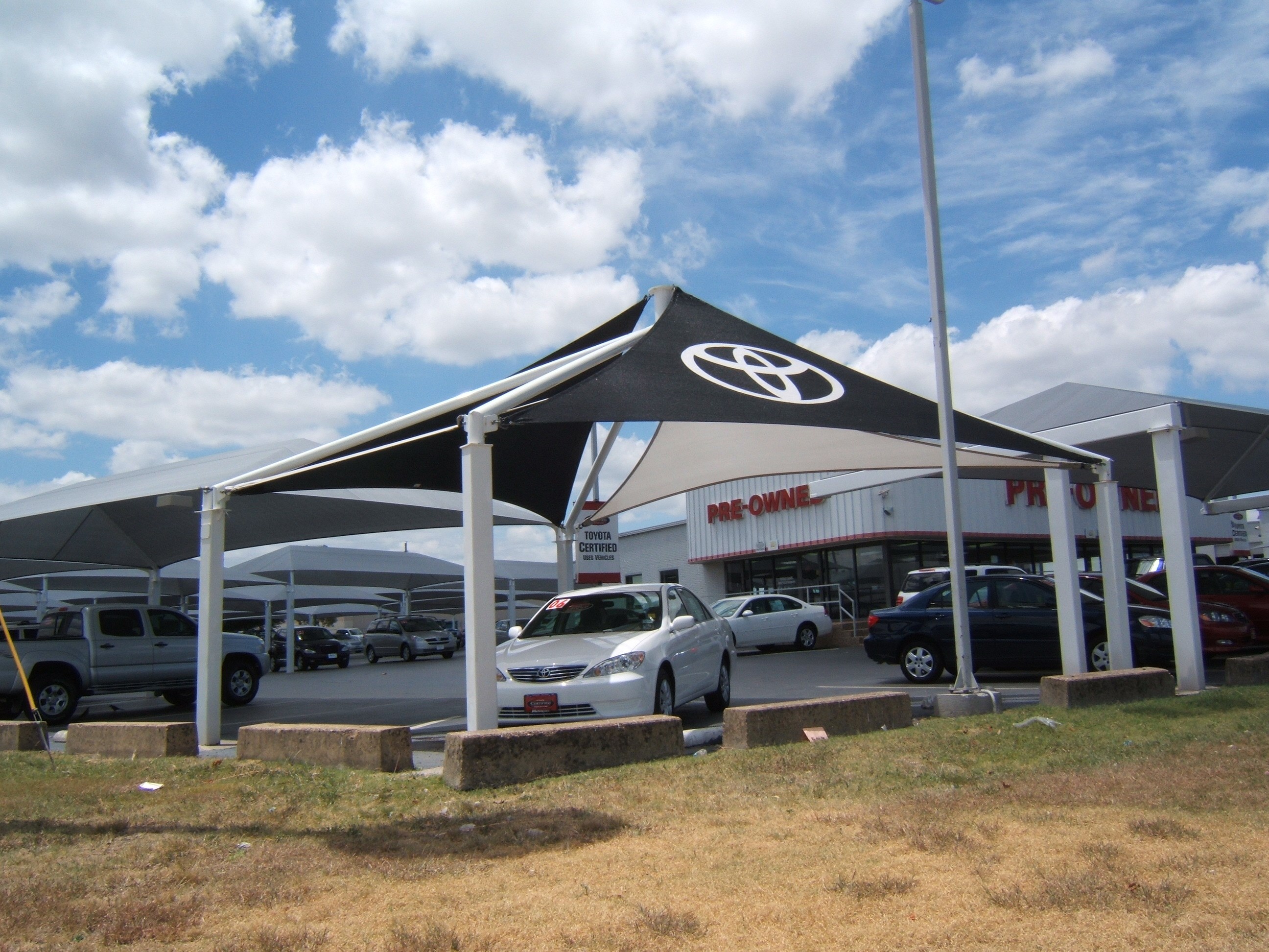 Shade structure at car dealership with Toyota logo