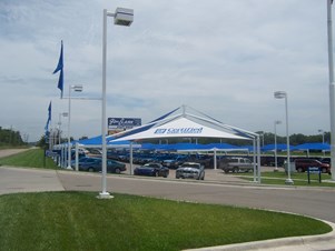 Custom shade structure at car dealership under flag