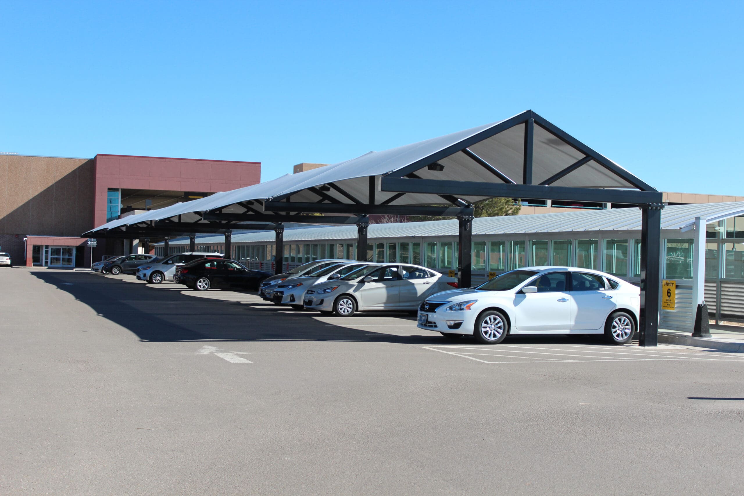 Car protected from sun and hail, cantilever shade structure
