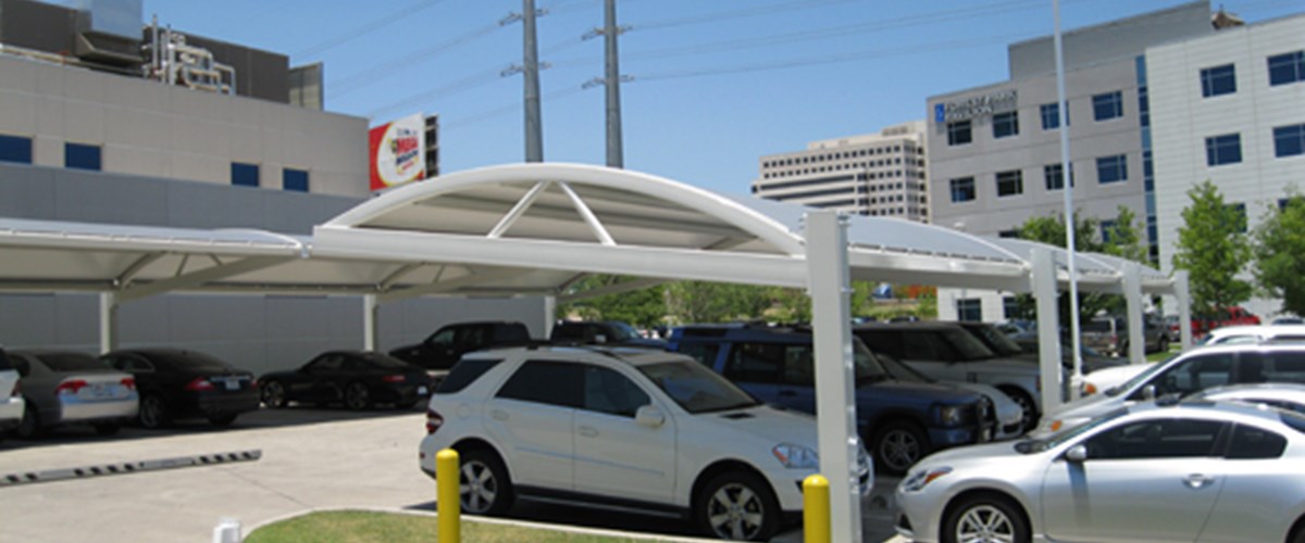 Cars parked under structure in front of hospital thumbnail