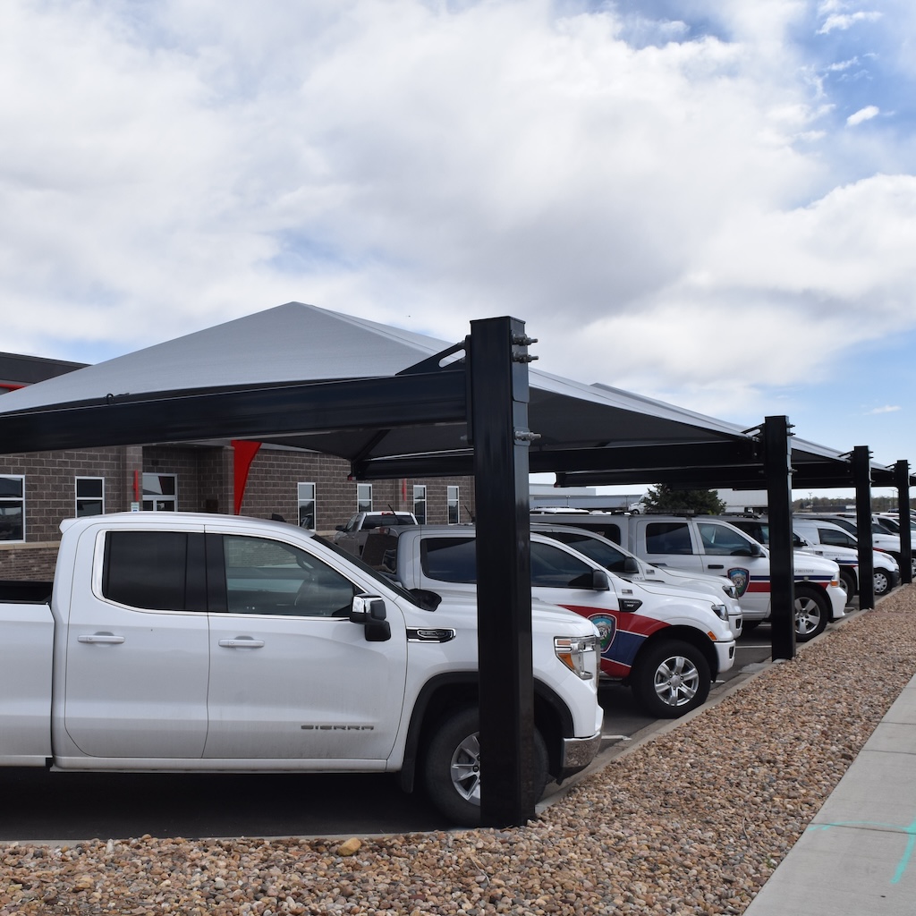 emergency vehicles covered by protective shade structure thumbnail